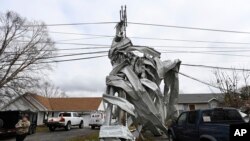 Metal roofing from a nearby church is wrapped around a utility pole, Dec. 10, 2023, in Clarksville, Tenn. Tornados caused catastrophic damage in Middle Tennessee on Saturday afternoon and evening, Dec. 9, 2023.