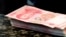 FILE - Chinese 100 yuan banknotes sit on a bank counter in Beijing, March 30, 2016. The Chinese currency has plummeted since former U.S. President Donald Trump was elected to another term on Nov. 5.