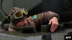 A Ukrainian tank crew member stands in a Leopard 1A5 not far from the front line in Kharkiv region, Nov. 24, 2023, amid the Russian invasion of Ukraine.
