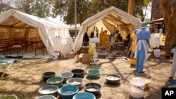 FILE - Health workers attend to patients suffering from cholera symptoms at a local hospital in Harare, Sept, 11, 2018. 