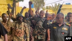 FILE - This picture released on the Sudanese Army's Facebook page on May 30, 2023, shows army chief Abdel Fattah al-Burhan cheering with soldiers as he visits some of their positions in Khartoum. 