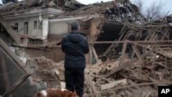 A resident looks at the remains of an industrial building after a Russian rocket attack in Sloviansk, Ukraine, Jan. 27, 2024. 