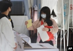 Taiwanese people cast their ballots at a polling station in Taipei, Taiwan, Jan. 13, 2024.