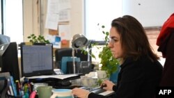 FILE - Immigration lawyer Caroline Turcotte-Brûlé works at her computer in her office in Montreal, Canada, Nov. 7, 2022. 