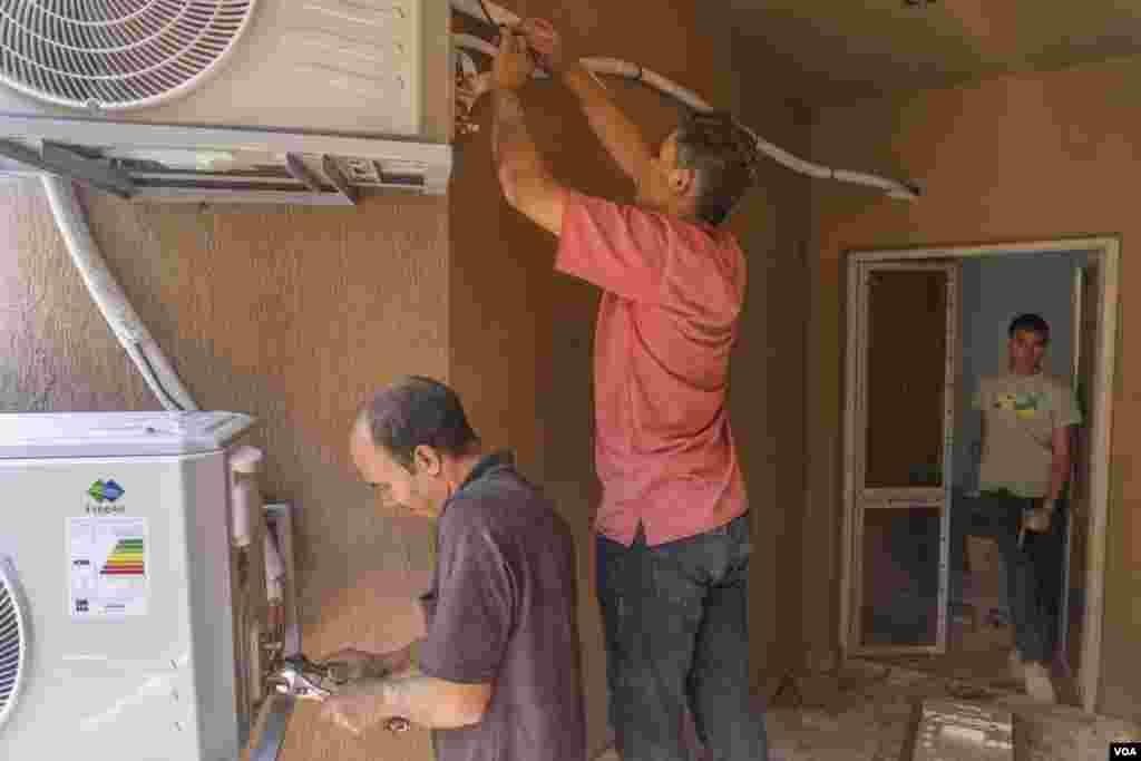 Walid (left), 33, a cooling technician, says, air conditioners "are becoming an essential item for more and more homes. Some people buy [AC units] before furniture.” (Hamada Elrasam/VOA)