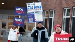 FILE - Candidate supporters stand outside a polling location in the presidential primary election, Jan. 23, 2024, in Windham, New Hampshire. Super Tuesday is feeling anything but for many Americans, with the leading presidential contenders already appearing set.