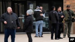 People embrace outside the McCreary Community Building where families were being reunited following a shooting at Perry High School, Jan. 4, 2024, in Perry, Iowa.