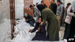 Relatives of Palestinians killed in an overnight Israeli bombardment mourn over their bodies at the European hospital morgue in Khan Younis, in the southern Gaza Strip, March 5, 2024.