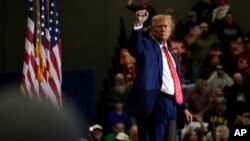 Republican presidential candidate former President Donald Trump stands on stage after speaking during a commit to caucus rally, Jan. 6, 2024, in Clinton, Iowa. 