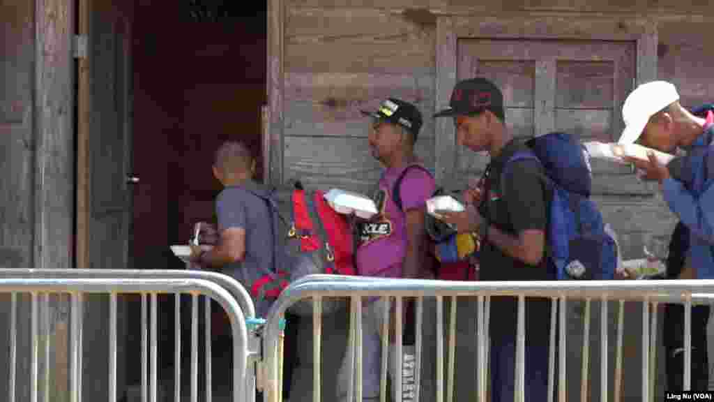 Migrants wait in line for free lunch of pasta with meat sauce offered by the Panama government on Feb. 24, 2024, at a migrant reception center at Lajas Blancas, Darien Province, Panama.