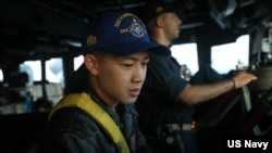 Lt. j.g. Bryan Nguyen stands watch on the bridge aboard the guided-missile destroyer USS Rafael Peralta in the Taiwan Strait, Nov. 2, 2023. 