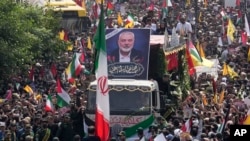 Iranians follow a truck carrying the coffins of Hamas leader Ismail Haniyeh and his bodyguard who were killed in an assassination blamed on Israel on Wednesday, during their funeral ceremony in Tehran, Iran, Aug. 1, 2024. 