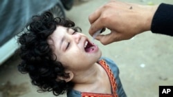 FILE - A health worker administers polio vaccine to a child in a neighborhood of Lahore, Pakistan, Nov. 27, 2023. Pakistan and Afghanistan are the last two countries where the virus continues to paralyze children. 