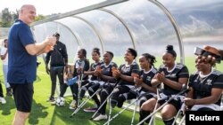 FILE - FIFA president Gianni Infantino talks to players from the Musanze women's amputee football team before launching the women's Amputee Football championship in Rwanda at the Pele Stadium in Kigali, Rwanda, March 16, 2023.