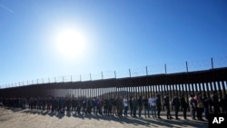 Люди у черзі по їжу від волонтерів після перетину мексиканського кордону, Каліфорнія, США, 24 жовтня 2023 р. Посилення південного кордону США пов'язують із намаганням демократів переконати республіканців голосувати за допомогу Україні. AP Photo/Gregory Bull