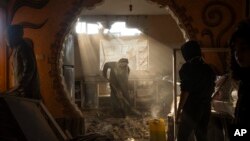 Palestinians look at a neighbor's damaged house after an Israeli strike in Rafah, southern Gaza Strip, Jan. 27, 2024. 