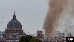 This general view shows smoke rising from a building at Place Alphonse-Laveran near the dome of the Church of the Val de Grace in the 5th arrondissement of Paris, on June 21, 2023.