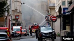 French firefighters work after several buildings on fire following a suspected gas explosion in the 5th arrondissement of Paris, June 21, 2023.