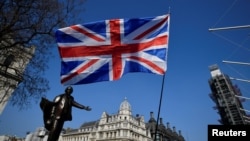 FILE - A British flag flutters in Parliament Square in London, March 29, 2019.