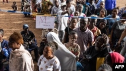 Voters wait in line at a voting station in Freetown on June 24, 2023 during the presidential vote.