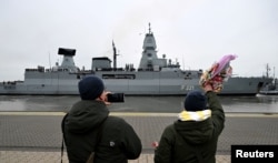 FILE - People wave and take pictures as the frigate Hessen is sent off to the Red Sea from Wilhelmshaven, Germany, Feb. 8, 2024, to participate in the international Aspides mission to protect shipping and ensure freedom of navigation in the Red Sea.