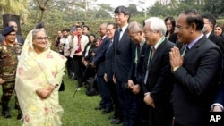 FILE - In this photograph released by Bangladesh Prime Minister's office, Prime Minister Sheikh Hasina, left, arrives to address a press conference following her election victory in Dhaka, Bangladesh, Jan. 8, 2024.