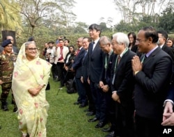 In this photograph released by Bangladesh Prime Minister's office, Prime Minister Sheikh Hasina, left, arrives to address a press conference following her election victory in Dhaka, Bangladesh, Jan. 8, 2024.