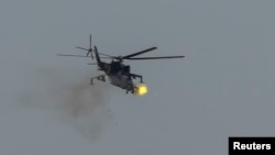 A Ukrainian military helicopter fires during drills in the north of Ukraine, June 1, 2023.