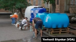Residents fill water containers because their city’s water pipes are almost dry in Nikopol, Ukraine, June 26, 2023.