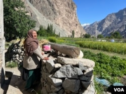A woman looks at her field on a sunny day in Turtuk village on the India-Pakistan border. (Bilal Hussain/VOA)