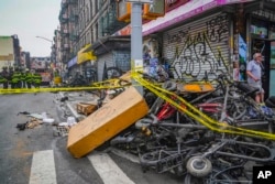 Tumpukan sepeda listrik yang hangus akibat kebakaran, yang menurut pihak berwenang bermula dari toko sepeda listrik dan menyebar ke apartemen di lantai atasnya di New York, Selasa 20 Juni 2023. (Foto AP/Bebeto Matthews)