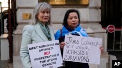 FILE - Human rights campaigners Helena Kennedy, left, and Rahima Mahmut hold placards as activists protest outside the British Foreign Office in London, Feb. 13, 2023. 