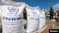 FILE - Displaced Palestinians wait to receive United Nations Relief and Works Agency (UNRWA) aid, amid the ongoing conflict between Israel and the Palestinian Islamist group Hamas, in Rafah, in the southern Gaza Strip, March 7, 2024.