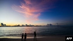 FILE - People walk along a beach at Vilimalé island in the the Maldives on Nov. 15, 2023. 