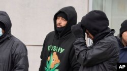 Michael Chavez, 27, of Costa Rica, center, stands in line with other migrants to receive food from the nonprofit Chi-Care, Jan. 11, 2024, in Chicago.
