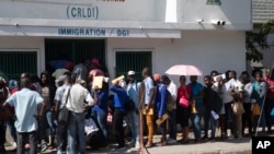 Haitianos hacen fila para solicitar un pasaporte, en Puerto Príncipe, Haití, el martes 10 de enero de 2023, tras el anuncio del presidente Joe Biden de una expansión masiva de la libertad condicional humanitaria para Cubanos, haitianos, venezolanos y nicaragüenses.