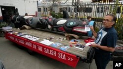 FILE - Freddie Lane, a member of the Lummi Nation, joins members of the Apache Stronghold group gathered in Los Angeles as they paint protest signs on March 20, 2023.