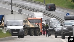 An APC and road police officers stand on the highway at the entrance to Moscow, Russia, June 24, 2023. 