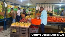 Clientes hacen sus compras de verduras y hortalizas en un negocio de comida y víveres varios en Maracaibo, Venezuela, el pasado 13 de julio de 2023.