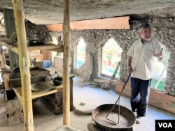 A resident of Turtuk, Mohammed Ali Bari, shows his museum to visitors in Turtuk. (Bilal Hussain/VOA)