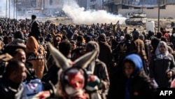 An Israeli tank rolls along a position as Palestinians flee Khan Yunis in the southern Gaza Strip on Jan. 26, 2024.