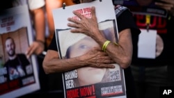 Relatives and friends of those kidnapped during the Oct. 7 Hamas cross-border attack in Israel hold photos of their loved ones during a protest calling for their return outside the Knesset, Israel's parliament in Jerusalem, Nov. 6, 2023.