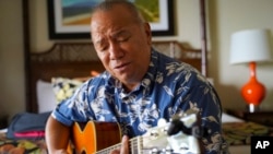 Charles Nahale plays the only guitar he took with him from the wildfire on Oct. 10, 2023, in Lahaina, Hawaii. 