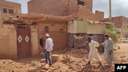 People check a damaged house in southern Khartoum, June 12, 2023, as deadly shelling and gunfire resumed after the end of a 24-hour cease-fire in Sudan.
