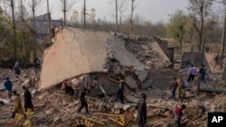 Kashmiri villagers inspect the debris of a damaged residential house where suspected rebels had taken refuge, after a gunfight in Kulgam south of Srinagar, Indian controlled Kashmir, Nov. 17, 2023. 
