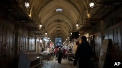 Palestinians walk through a market ahead of the holy Islamic month of Ramadan in the Old City of Jerusalem, March 7, 2024. 