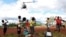 FILE - Children in Mulanje look on as a military helicopter carry doctors and medical supplies to Muloza on the border with Mozambique which are cut off after the tropical Cyclone Freddy outside Blantyre, Malawi, March 18, 2023.