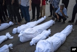 Palestinians mourn their relatives killed in the Israeli bombardment of the Gaza Strip, in front of the morgue in Deir al Balah, Nov. 1, 2023.