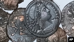 A picture made available by the Italian Culture Minister showing some of the discovered ancient bronze coins.