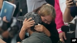 FILE - A relative hugs a Thai overseas worker who was evacuated from Israel, as he and others arrived at Suvarnabhumi International Airport in Samut Prakarn Province, Thailand, on Oct. 12, 2023. 